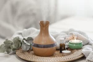 Cozy spa composition with aroma oil diffuser lamp on a blurred background.